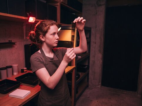 Close-up of student examining film negative against darkroom light