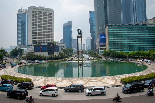 Jakarta, Indonesia - August 13, 2026: Bundaran Hotel Indonesia with the Selamat Datang Monument, reflecting pool, surrounding skyscrapers, and traffic in Central Jakarta.