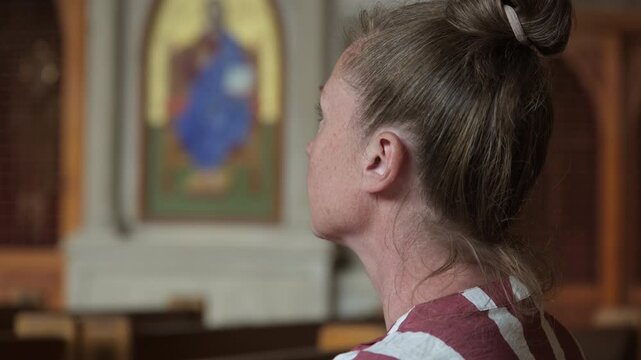 Portrait of woman parishioner in prayer hall in temple, spiritual peace, reflection