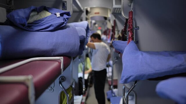 Train sleeping car interior with bunks, passenger preparing for long journey