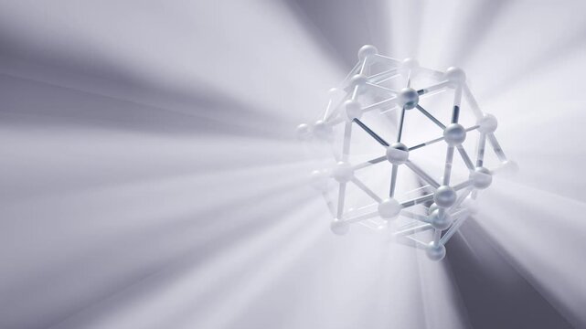 A metallic 3D nanocage structure rotates smoothly as radiant white light rays beam through its geometric lattice against a soft silver background.
