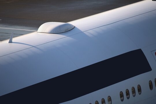 Aircraft fuselage close-up of internet satellite and wifi antenna. Passenger aircraft internet connection radome hump on top.
