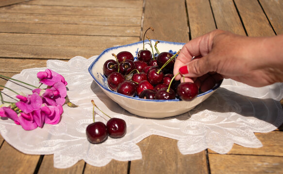 Fresh Ripe Cherries in Sunlight on a Rustic Cottage Garden Table
