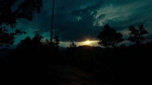 Sunrise Burst Behind Forest Trees Silhouette with Dark Moody Teal Sky