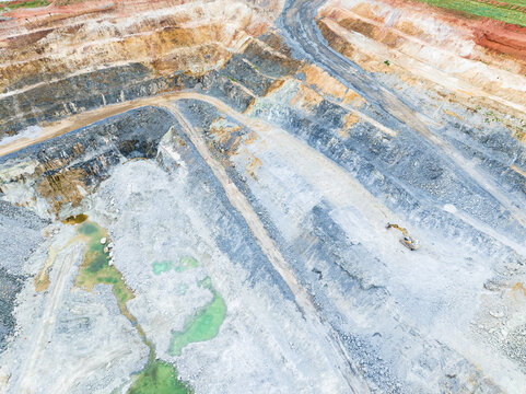 Aerial view of the Three Springs Talc mine showing deep open-pit excavation, layered rock formations, and heavy machinery in Womarden, Western Australia, Australia.