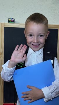 close-up video of joyful boy with school backpack, and a chalkboard behind, ready for school. perfect for back-to-school concepts and early education promotion