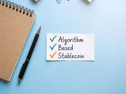 Algorithm based stablecoin text on a paper note with a notebook and pen on a blue desk surface