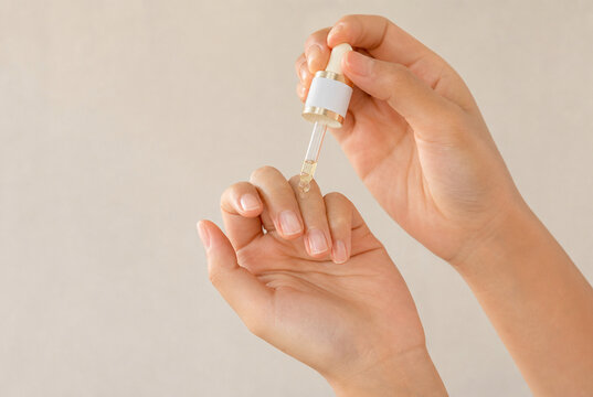 Nail Care Hands Applying Essential Oil To Cuticles With Glass Dropper