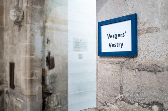 Shallow focus of a typical Verger's Vestry sign seen in a famous English cathedral. Note the ancient stonework wall, recently renovated.