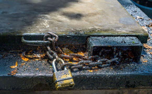 Closeup of Lock and Chain on Top of a Grimy Outdoor Grease Trap