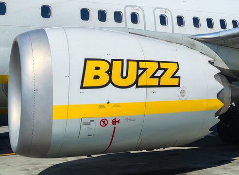 Bari, Italy - July 5, 2026: Buzz airline jet engine close-up on Boeing aircraft fuselage at airport, yellow logo visible on turbine nacelle