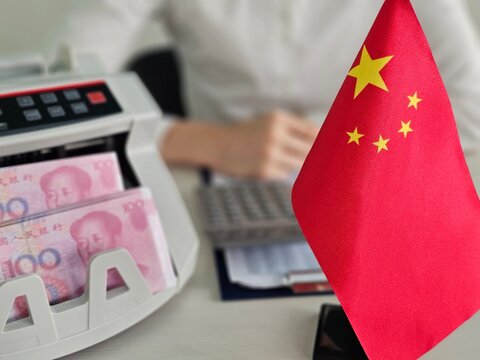 Counting Chinese currency at a financial office with a calculator