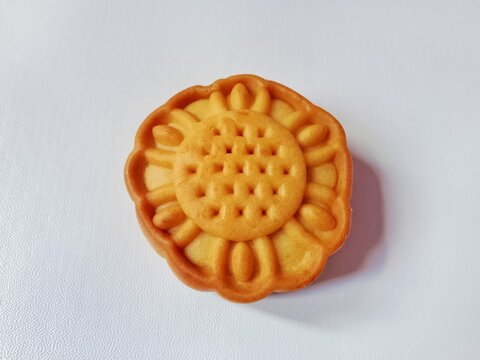 Top view of a single traditional Chinese mooncake shaped like a flower on a clean white background