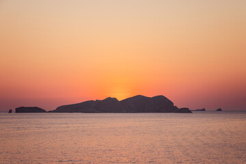 Fototapeta premium Sa Conillera occupies this composition from Platges de Comte on Ibiza, Spain with afterglow, lit by soft post sunset ambient glow.