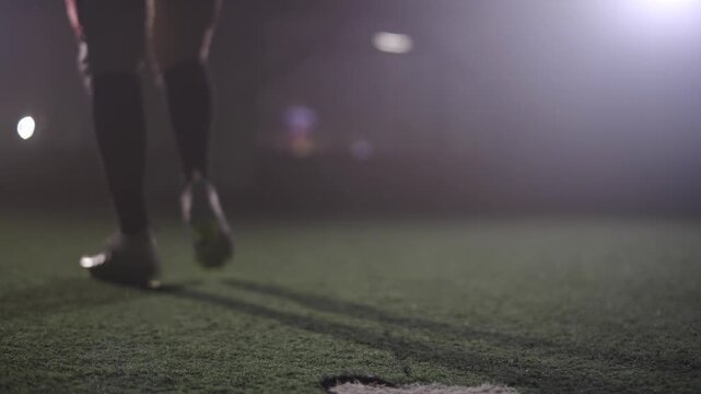 American football player kicks the ball with his foot.