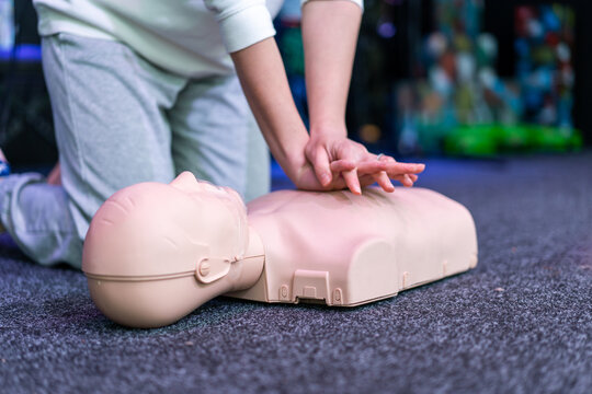 People practicing cardiopulmonary resuscitation CPR and basic life support techniques on a medical training manikin during a first aid course. Emergency response education and lifesaving skills.