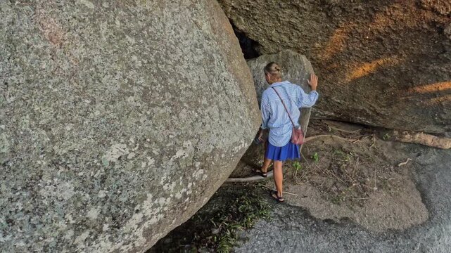 Woman and child enter gap between large stones