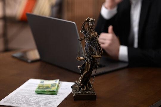 Bribery and Corruption Concept with Cash on Legal Documents and Lady Justice Statue