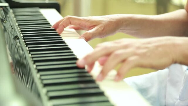 Musician playing piano keyboard keys close up indoors