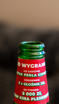 Rzeszow, Poland - June 8, 2026: Perla Export beer bottle neck with promotional label advertising weekly prize of 5000 PLN and JBL speaker giveaway in Polish