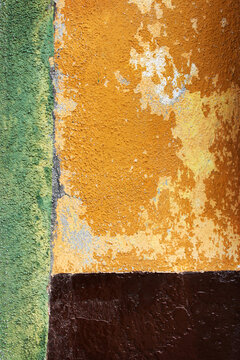 Abstract Weathered Wall Texture Background with Peeling Yellow Ochre Green and Brown Paint - Rustic Distressed Stucco Surface
