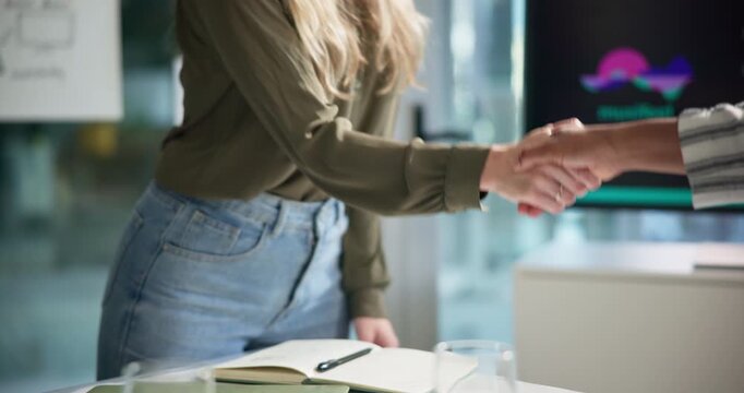 Business woman, handshake and meeting with colleague for partnership, hiring or agreement at office. Closeup of employees shaking hands for b2b, deal or recruiting together by desk at workplace