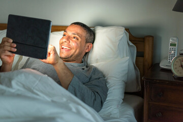 Fototapeta premium Man enjoying tablet in bed.