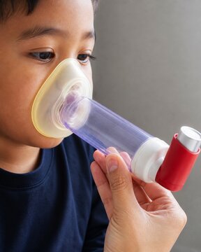 Child receiving nebulizer breathing treatment with caregiver assistance