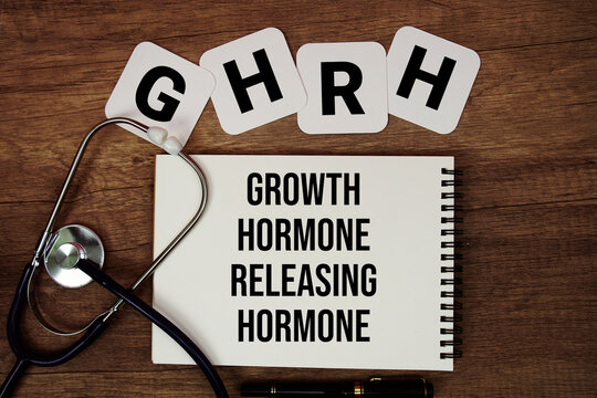 GHRH Growth Hormone-Releasing Hormone. text written on notepad with stethoscope on wooden background