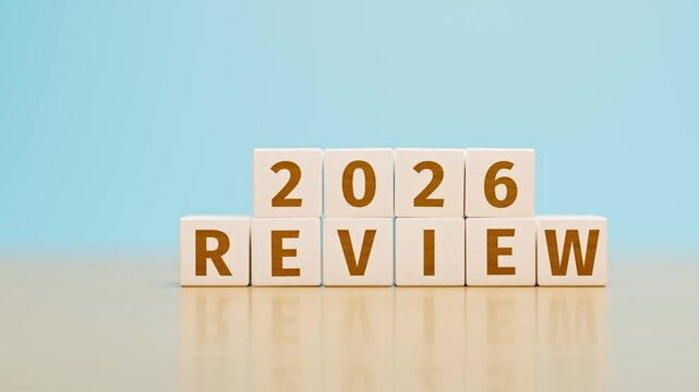 Wooden toy cubes forming the text "2026 REVIEW". Concept for reviewing what happened in the year 2026. Tracking shot.