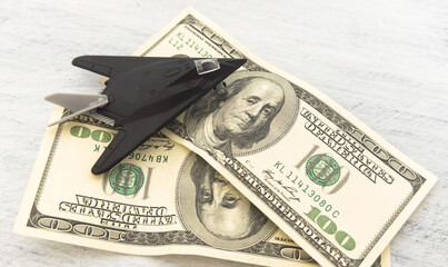 Fototapeta premium military miniature toy airplane on dollars background
