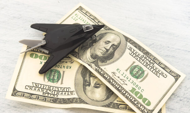 military miniature toy airplane on dollars background