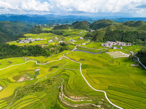 Aerial view of winding road through green terraced rice fields and mountain villages