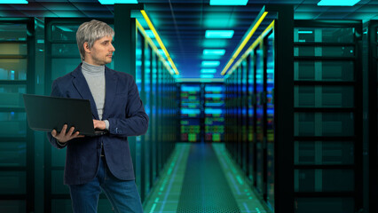 Fototapeta premium Data center operations: IT specialist with laptop inspects server infrastructure inside modern illuminated server room.