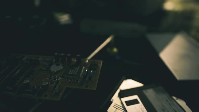 Moody motherboard and floppy disk silhouette, inspector measuring signal traces, shallow depth, bokeh highlights, muted green palette, intimate tech atmosphere