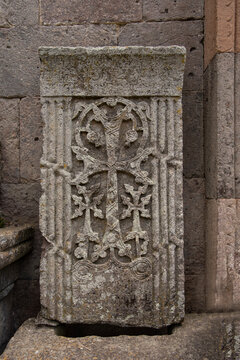 Detailed close-up of textured ancient Armenian grey tuff Khachkar cross-stone slab with weathered medieval carving