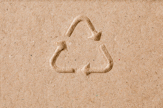 Recycling Symbol Embossed on Rough Kraft Cardboard Texture Eco Background