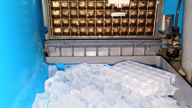 Automatic commercial ice maker machine producing clear ice cubes in blue bin concept.