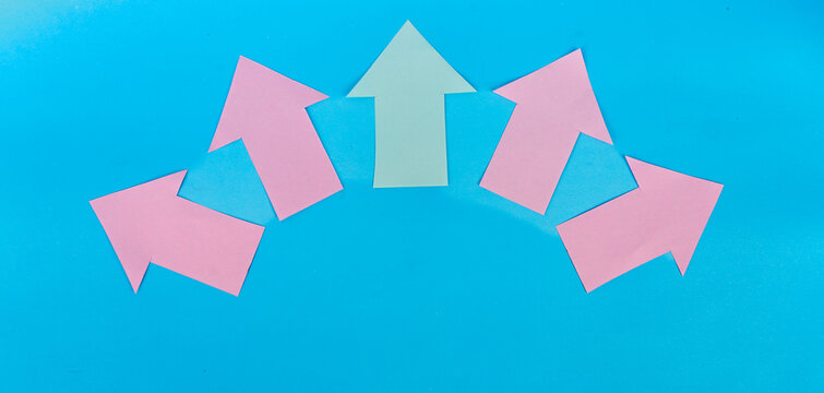 Green upward arrow among four pink arrows spreading in different directions on blue background
