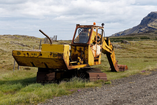 Abandoned Rusty JCB Excavator in a Scenic Mountain Landscape