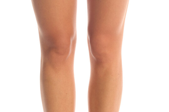 Close-up of woman's knees and lower legs, front view smooth skin detail, healthy skin concept, isolated on white background.