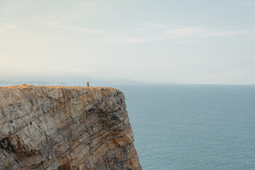 People standing on a dramatic cliff edge at Cape Peñas in Asturias. Spain. Providing a sense of scale and illustrating themes of adventure. Freedom. Solitude © Víctor Sánchez