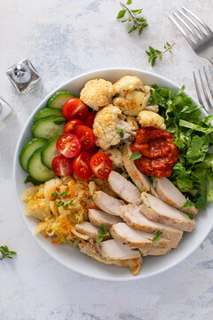 Healthy lunch bowl with grilled chicken, cabbage and fresh vegetables