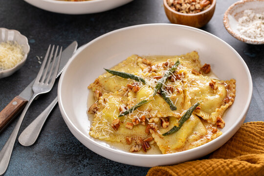 Pumpkin ravioli with brown butter and sage sauce served in bowls