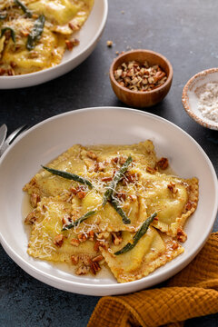 Pumpkin ravioli with brown butter and sage sauce served in bowls