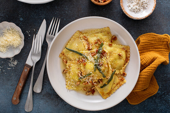 Pumpkin ravioli with brown butter and sage sauce served in bowls