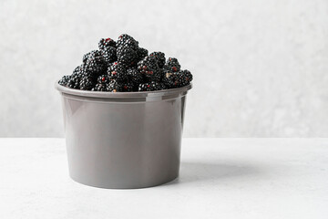 a bucket of blackberries on light background © JuliaLavleis