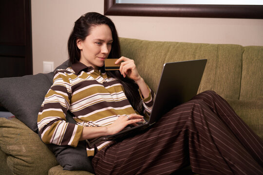 Woman shopping online on a couch in living room