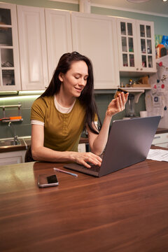 Woman working on laptop while holding a snack