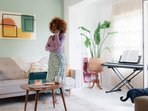 Anxious woman talking on the phone in living room 